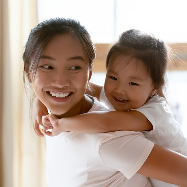 MotherandDaughterIndoors Mother and Daughter smiling in front of a window